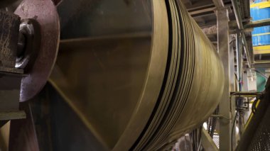 Maden fabrikasındaki büyük soyunma değirmeninin manzarası. Stok görüntüleri. İnşaat malzemeleri üretim fabrikasının içini dönen bir makineyle görüntüle.