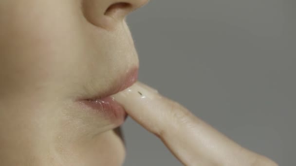 Közelkép egy nőről, aki szürkén szopogatja az ujját. Készletfelvétel. Oldalnézet egy nő nyalogatja az ujját lassan egy szexi módon. — Stock videók