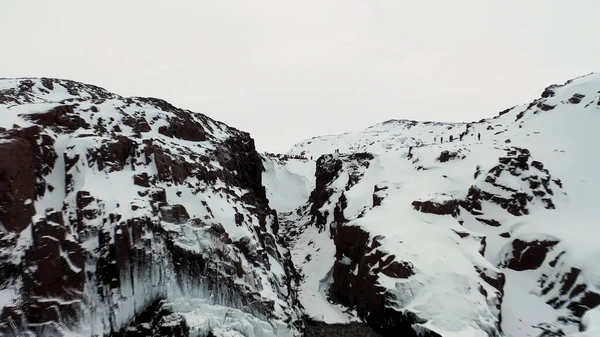 Vista aerea della Norvegia e della costa innevata vicino al mare nella stagione invernale, in Europa. Un filmato. Colline bianche innevate, paesaggio naturale di rocce innevate e mare freddo e calmo . — Foto Stock