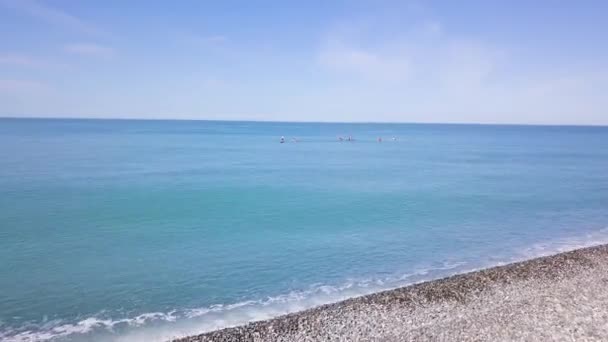 Group of people swim on SUP Board. Clip. Beautiful seascape with people resting on water with SUP boards. Top view of turquoise sea with people on swimming boards — Stock Video