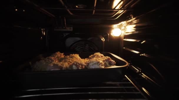 Close up of raw chicken under the cheese in the oven. Action. Meat of chicken under the sauce and cheese being baked in the oven, concept of food and cooking. — Stock Video