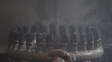 Su çeşme mekanizmasını kapat. Şarjör. Çalışan çeşmenin metal boruları birçok nozülden havaya yükselen su akıntılarıyla birlikte..