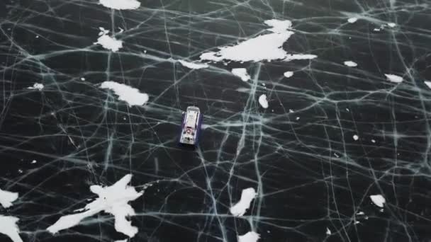 Véhicule aéroglisseur typique traversant un lac glacé en hiver. Clip. Vue aérienne du véhicule à coussin d'air entrant dans un patin sur une surface de glace claire fissurée, lac Baïkal, Sibérie, Russie. — Video