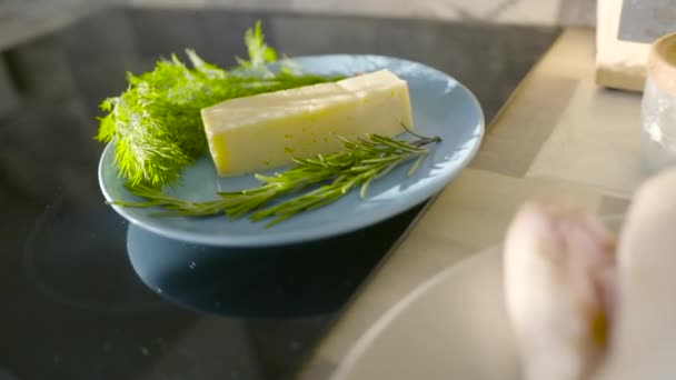 Ingrédients pour cuire le poulet. L'action. Fromage frais et herbes dans une assiette pour la cuisson. Gros plan sur le fromage, le romarin et l'ail pour un goût raffiné du plat. Cuisine maison — Video