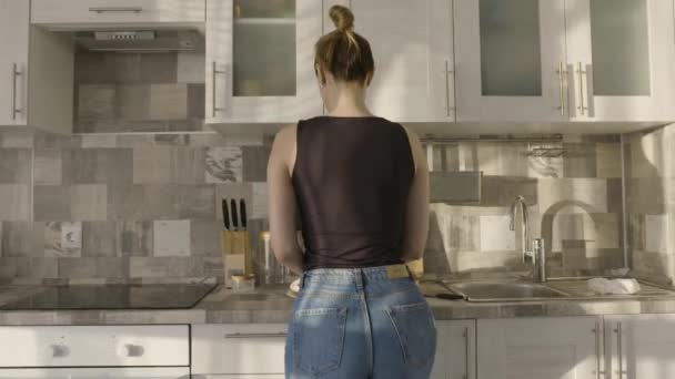 Atraktivní žena vaří kuře. Akce. Sexy žena tančí kuře v kuchyni. Krásná žena vaří s vášní doma — Stock video