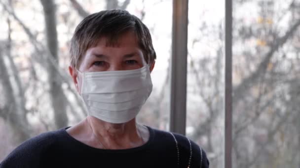 Primo piano di donna anziana in maschera protettiva. Concetto. Ritratto di donna anziana in maschera protettiva durante l'epidemia di virus. Gli anziani dovrebbero prendere meglio proteggersi durante il virus — Video Stock