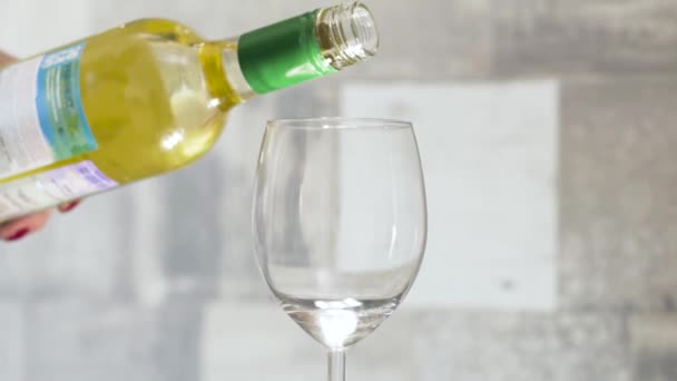 Vinho branco é derramado em vidro no fundo claro. Acção. Um copo de vinho branco de manhã para solteira ao pequeno-almoço. Bebida alcoólica — Vídeo de Stock