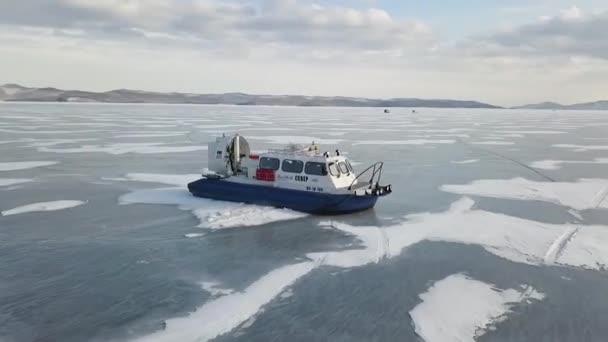 Aérea de la máquina khivus sobre fondo de invierno. Clip. Hovercraft deslizamiento rápido en la superficie del lago congelado transparente Baikal, belleza de la naturaleza . — Vídeos de Stock