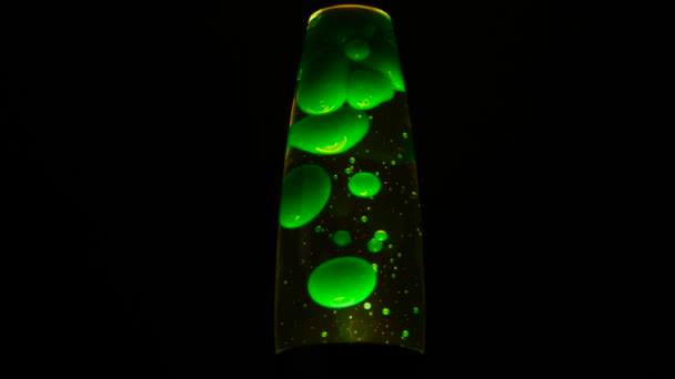 Grön lavalampa på svart bakgrund. Begreppet. Vacker neonljus lavalampa i totalt mörker. Retro neon nattljus med rörliga bubblor. Lavalampa — Stockvideo