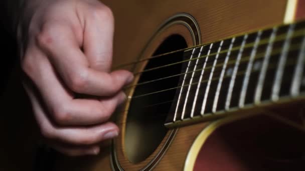 Primer plano del hombre tocando la guitarra. Concepto. Guitarrista profesional mueve los dedos a lo largo de cuerdas de guitarra maravillosamente. Guitarra atmosférica tocando — Vídeo de stock