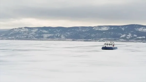 Hovercraft no gelo do lago Baikal no inverno. Clipe. Vista aérea do veículo almofada de ar no gelo espesso do lago congelado, transporte desportivo e conceito extremo . — Fotografia de Stock