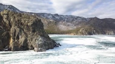 Donmuş göl ve dağlarla nefes kesici doğal arka plan manzarası. Şarjör. Ormanlık tepeler ve dev su deposunun mavi buzlu yüzeyi.