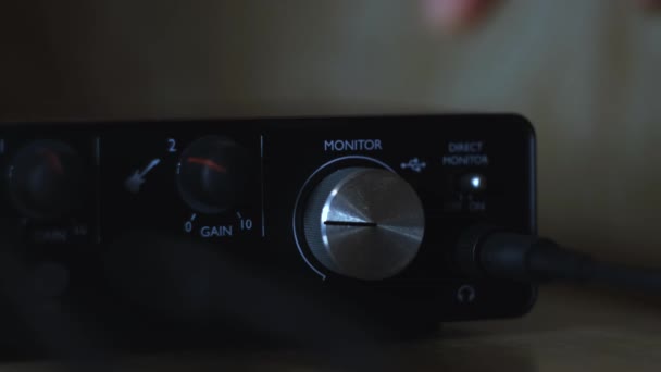 Ajuste manualmente o controlador de volume da interface de áudio para gravação em casa. Conceito. Fechar a placa de som externa sobre fundo desfocado . — Vídeo de Stock