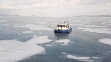 Sibirya Gölü 'nde kayan Hovercraft, kış doğasının güzelliği. Şarjör. Buz üzerinde hareket eden hava yastığı aracının hava görüntüsü, aşırı turizm kavramı.