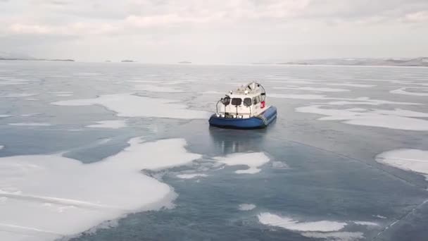 Vznášedlo klouzající po sibiřském jezeře, krása zimní přírody. Klip. Letecký pohled na vzduchový polštář vozidla pohybující se na ledu, koncept extrémní turistiky. — Stock video