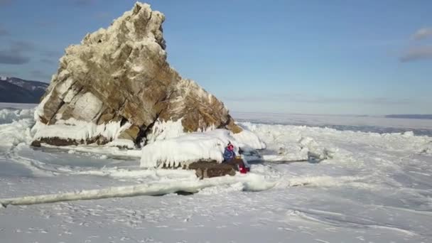 Kvinna mediterar medan du spelar stål tunga truminstrument. Klipp. Frihet och vinter turism koncept, kvinna sitter och njuter av utsikten över en frusen sjö Baikal yta. — Stockvideo