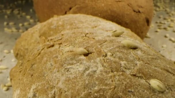 Hausgemachtes Brot mit Getreide, Samen und Getreide. Archivmaterial. Großaufnahme von leckerem Laib frisch gebackenem Brot, das auf dem Tisch liegt, Konzept des Essens. — Stockvideo