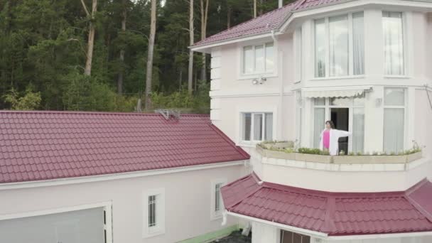 Donna che si estende sul balcone. Un video. Vista superiore della donna che si gode la mattina sul balcone del grande cottage di campagna sullo sfondo della foresta — Video Stock