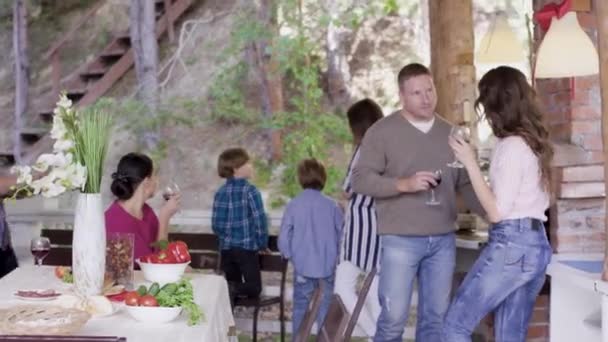 Los amigos están celebrando un evento en el país. Vídeo. Grupo de amigos ricos celebran evento en casa de campo. Empresa cultural y divertida con copas de vino — Vídeos de Stock