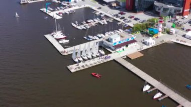 Yelkenli yatlarla Marina 'nın en üst manzarası. Video kaydı. Yat ve regattalar için şehir otoparkı. İnsanlar regattas 'taki yarışmalar için rıhtımda toplanıyor.