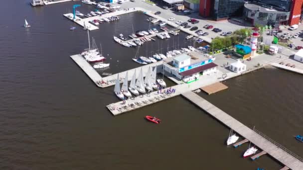 Top uitzicht op Marina met zeiljachten. Een video. City Parking voor jachten en regatta 's. Mensen verzamelen zich op de pier voor wedstrijden op regatta 's — Stockvideo