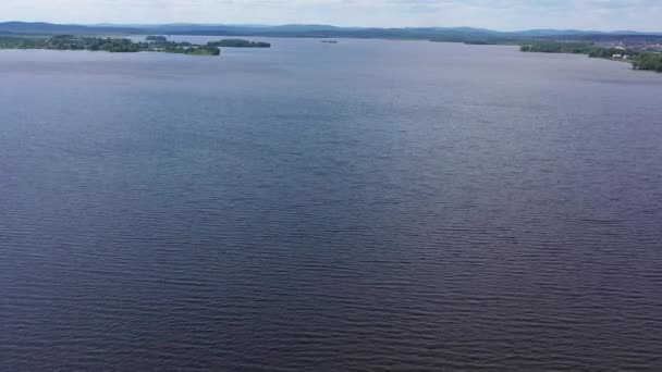 Κάτοψη της όμορφης λίμνης στο φόντο του ορίζοντα με τον ουρανό. Βίντεο. Πανόραμα πεντακάθαρης λίμνης και πράσινων ακτών με όμορφο ορίζοντα τον γαλάζιο ουρανό — Αρχείο Βίντεο