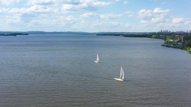 Vista dall'alto di yacht a vela splendidamente galleggianti. Un video. Barche a vela galleggiano nel lago su un bellissimo paesaggio con orizzonte collinare e cielo blu — Video Stock