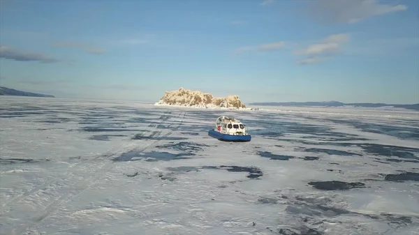 Захоплююча крижана поверхня водойми, пов'язана густим льодом і рухомим повітряним судном. Кліп. Вид з повітря групи туристів, які подорожують всередині повітряної подушки на замерзлому озері . — стокове фото