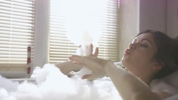 Kobieta bawiąca się kąpielą z bąbelkami. Nagranie. Piękna kobieta cieszy się i relaksuje w kąpieli z bąbelkami. Sexy kobieta gra z pianki w łazience — Wideo stockowe