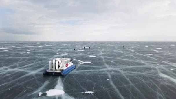 Vista aérea da máquina se movendo no lago incrível congelado. Clipe. Veículo de hovercraft típico na superfície de gelo craked clara, lago Baikal, Sibéria, Rússia . — Vídeo de Stock