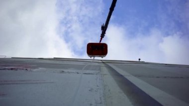 Memlekette asansörde çalışan işçilerin alt görüntüsü. - Sanat. Asansördeki işçiler ev duvarlarını onarıyor. Arkaplan mavi gökyüzünde çok katlı bina onarım duvarı yüksekliğindeki işçiler