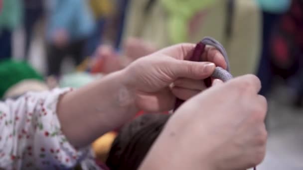 Close-up van een vrouw die touwen mooi vastbindt. Kunst. Vrouw bindt touwen en maakt ambachten voor eerlijke. Vrouw weeft mooie bundels touwen tijdens creatieve beurs — Stockvideo