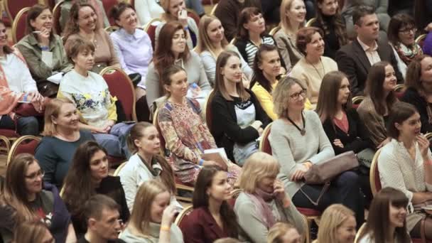 Groot vrouwelijk publiek zit op conferentie. Kunst. Hall is gevuld met de belangrijkste vrouwelijke publiek op professionele training. Vrouwen kijken aandachtig naar sprekers — Stockvideo