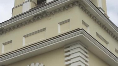 Yüksek beyaz ve bej çan kulesinin alt görüntüsü, mimari ve din kavramı. Stok görüntüleri. Ortodoks Kilisesi 'nin altın haçı ve kule saati var..