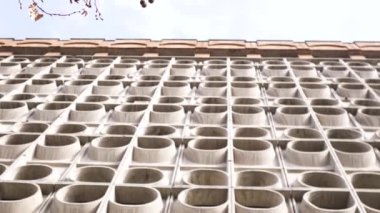 Sovyet mimarisi sonrası, duvarın alt görüntüsü. - Sanat. Sıra dışı beton duvar ya da mavi bulutlu arka planda yuvarlak simetrik desenli çit.