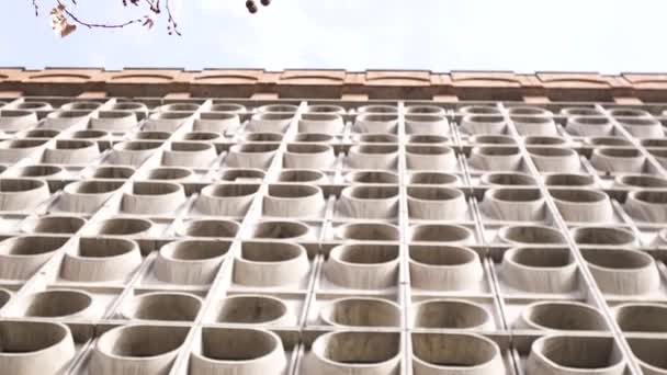 Postsovjetisk arkitektur, bottenvy över väggen. Konst. ovanlig cementvägg eller staketet med runda symmetriska mönster på blå grumlig himmel bakgrund. — Stockvideo
