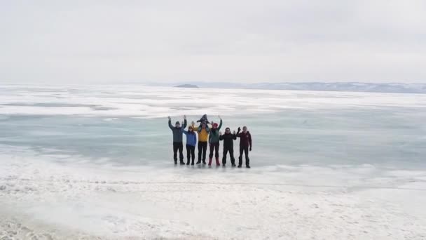 일단 의 관광객들이 얼어붙은 바이칼호의 얼음을 따라 여행 한다. 클립. 행복 한 사람들 이 얼음 같이 차가운 표면에서 서 있는 모습, 활동적 인 생활 방식 과 극단적 인 생활 방식에 대해 카메라에 손을 흔드는 모습 — 비디오