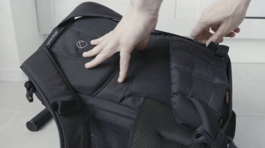 Laptop ya da diğer cihazlar için koruyucu yumuşak malzeme paketliyorum. Başla. Erkek eli kapalı. Sırt çantasının içine siyah köpük kauçuk katmanı koyuyor..