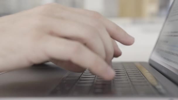 Trabalhando em casa com laptop, mãos masculinas no teclado. Acção. Visão lateral de perto de mãos que digitam no teclado do computador, conceito de tecnologias modernas . — Vídeo de Stock