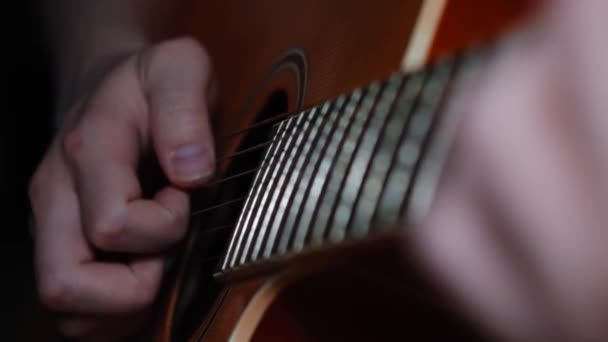 Hombre tocando guitarra clásica, acústica e interpretando canciones de bardo. Concepto. Primer plano de manos masculinas tocando la guitarra, tomando acordes en el cuarto oscuro, música en vivo . — Vídeos de Stock