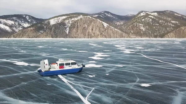 冷凍湖バイカルシベリア、ロシア上のホバークラフト輸送。クリップ。高い山、凍結湖と青空と絵のような冬の風景の空中ビュー. — ストック写真