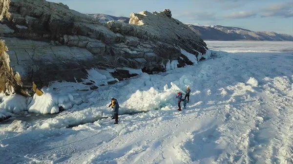 Lago Baikal, belo gelo azul espesso com rachaduras em um dia ensolarado. Clipe. Turistas exploram natureza russa de tirar o fôlego na temporada de inverno, conceito de viagem extrema . — Fotografia de Stock