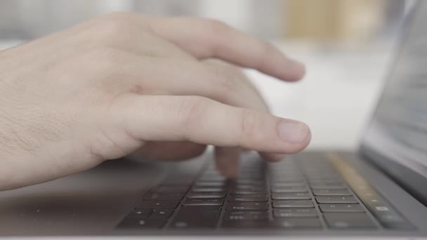 Trabalhando em casa com laptop, mãos masculinas no teclado. Acção. Visão lateral de perto de mãos que digitam no teclado do computador, conceito de tecnologias modernas . — Vídeo de Stock