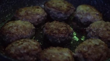 Kızartma tavasında domuz eti ve köfte yakın çekim. Kavram. Yuvarlak ve lezzetli et pirzolaları sebze yağı, yemek ve yemek konseptinde kızartılıyor..