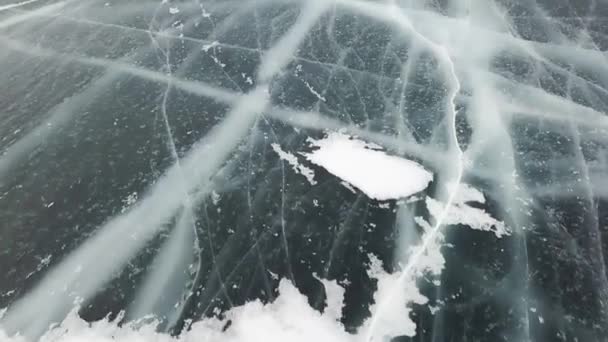 清澈光滑的冰雪覆盖的冬季风景.剪断。俄罗斯著名的自然地标，蓝色的冰和深深的裂缝，俯瞰着一个冰冻的湖泊. — 图库视频影像