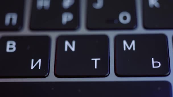 Close-up van het toetsenbord van een laptop in zwart-wit kleuren. Actie. Concept van moderne computertechnologieën, laptop toetsenbord met gloeiende letters. — Stockvideo