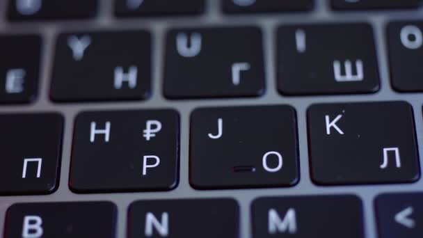 Close-up van het toetsenbord van een laptop in zwart-wit kleuren. Actie. Concept van moderne computertechnologieën, laptop toetsenbord met gloeiende letters. — Stockvideo