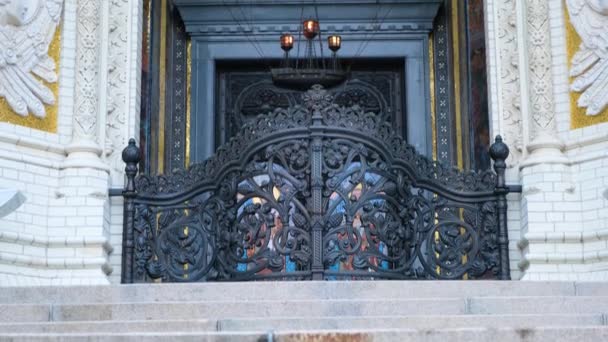 Detalles de la entrada principal arqueada a la Catedral. Concepto. Hermosa entrada detallada con bóveda arqueada e iconostasis en Catedral. Puertas de hierro forjado al templo y bajorrelieves — Vídeos de Stock