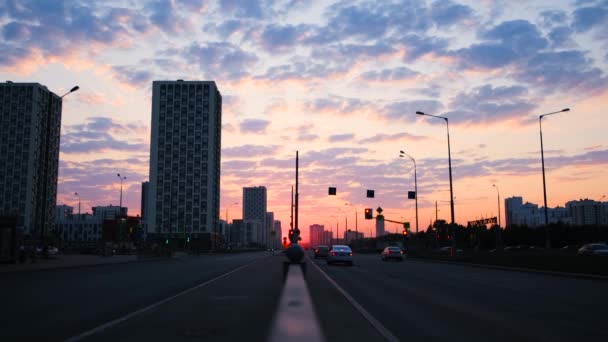 일몰 광경을 배경으로 도시 도로의 아름다운 풍경이 구름으로 뒤덮여 있다. 개념. 밝은 저녁 하늘과 구름이 있는 두 개의 고속 도로의 교통 상황과 대조적 인 광경 — 비디오