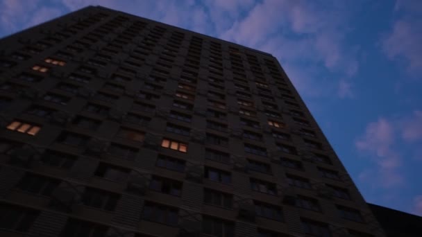 Untere Ansicht eines Wohnkomplexes von Häusern am Abend. Konzept. Moderne Fassade der Wohnungen im komplexen Hintergrund Abendhimmel — Stockvideo